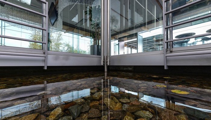 Vodacom’s Midrand Innovation Centre has the appearance of a transparent glass box with overhangs, natural ventilation, low-energy design with solar installation, and an inner ‘wetland’ courtyard, designed to achieve a biodiverse site of which 70% was covered in indigenous and endemic vegetation. 